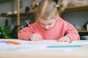 A pre-kindy child is learning how to write and draw at Fireflies Early Learning